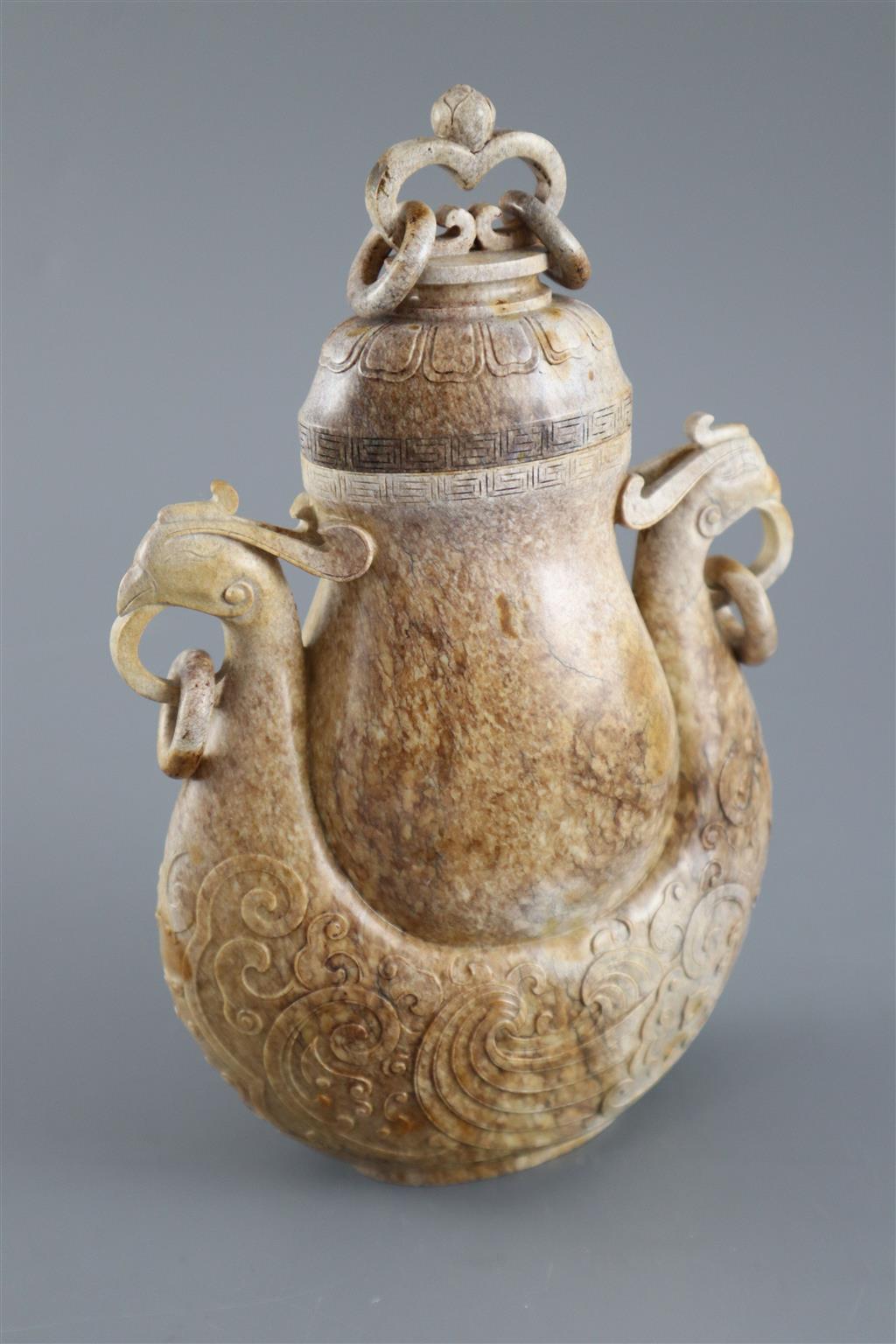 A Chinese archaistic burnt jade phoenix vase and cover, 20cm high